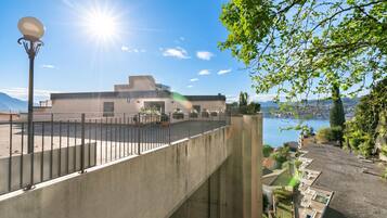 Ein modernes Gebäude mit Flachdach, Betontreppe und Blick auf ein Gewässer.