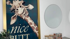 A framed giraffe artwork with the text "nice butt" on a wall. - Well-appointed Stylish Apartment in Central Gloucester (Gloucestershire)