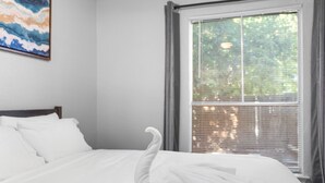 A neatly made bed with white linens and a swan-shaped towel arrangement. - Beautiful 1BD/1BA in University Hills jkxg (Austin)