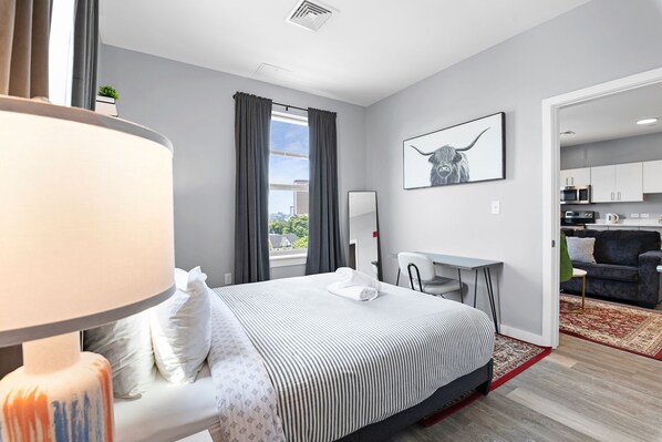 A modern hotel room with a bed, a desk, and a view of the city. - Stylish 1BR Near Encore vdw4 (Everett)