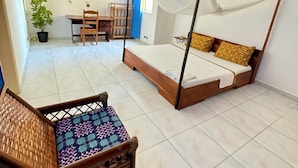 Una habitación con una cama, un escritorio, una silla y una planta en maceta.
