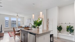 A modern kitchen with a central island, built-in appliances, and pendant lighting. - Luxury 2BD/2BA Next to Airport 3689 (Del Valle)
