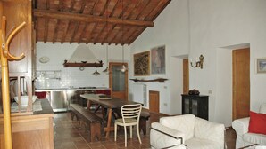 Una cocina amplia con comedor, techo de madera y una sala de estar acogedora con sofá y sillón.