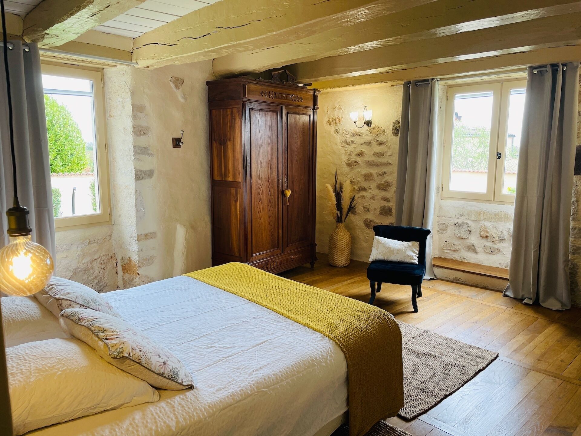 A bedroom with a bed, a wardrobe, a chair, and a lamp.