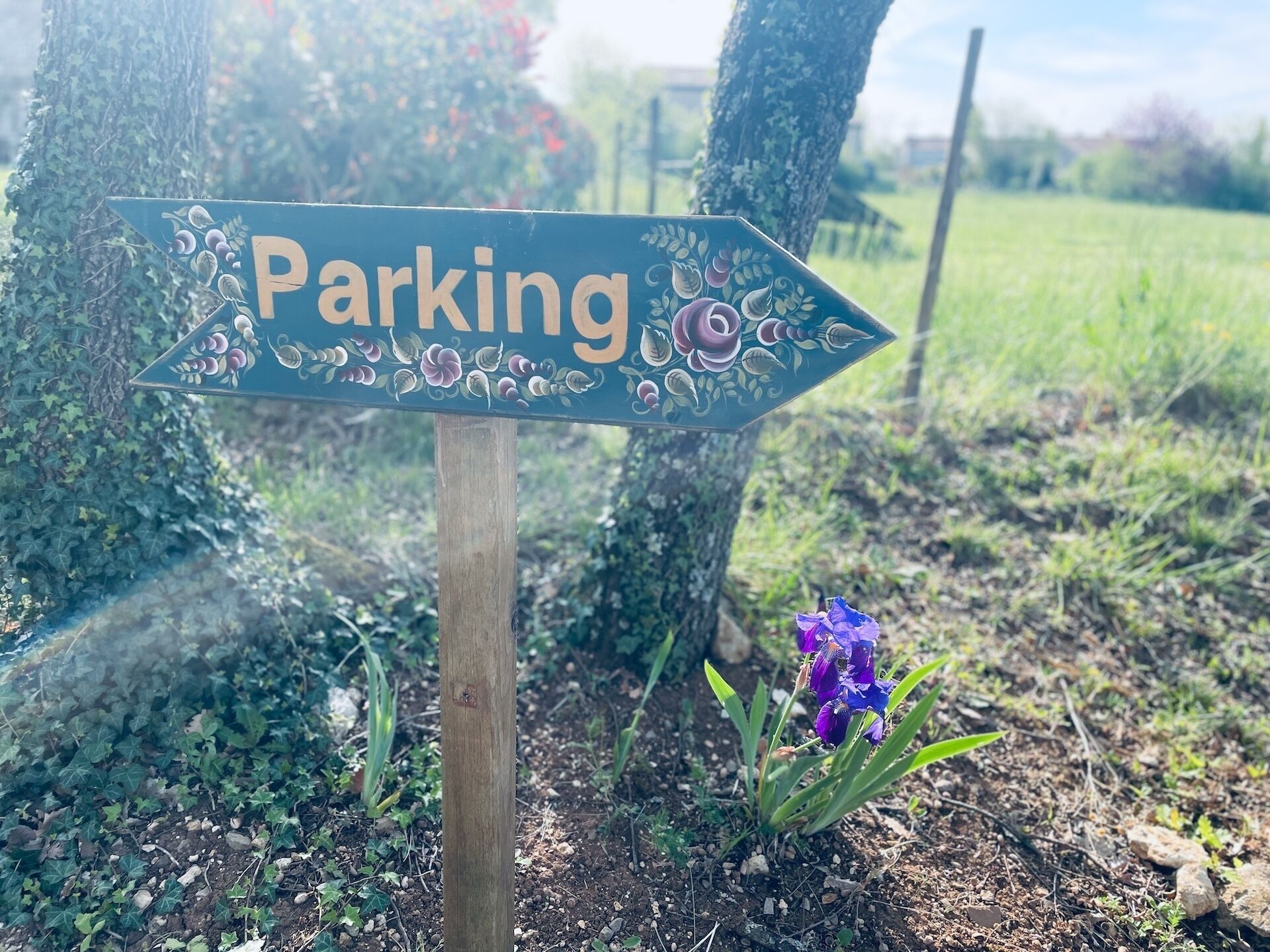 Un panneau de signalisation indiquant la direction du parking, avec le mot « Parking » et une flèche pointant vers la droite.