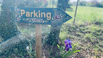 Un panneau de signalisation indiquant la direction du parking, avec le mot « Parking » et une flèche pointant vers la droite.