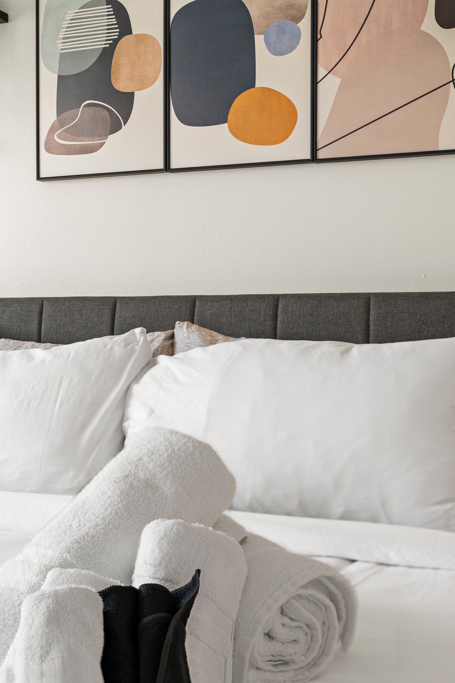 A neatly made bed with white linens and a folded towel.