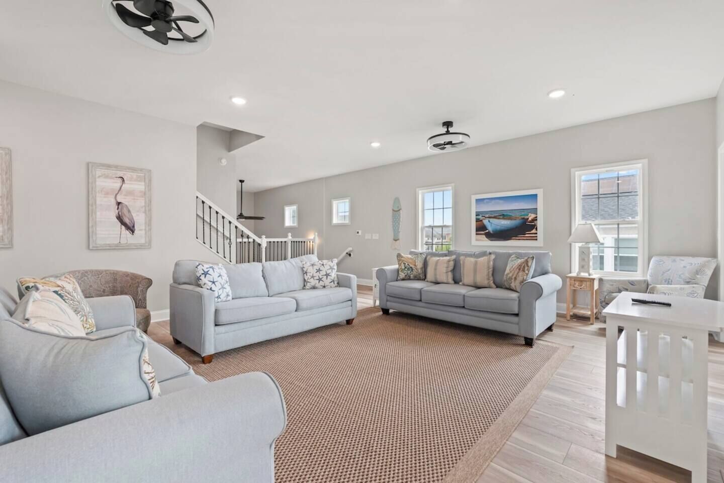A spacious living room with two sofas, a coffee table, and a staircase.