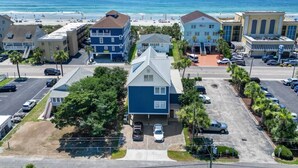 A coastal hotel with multiple buildings, a parking lot, and a beach view. - Epic 7BR Getaway - Pool, Game Room, Put-put, Beach (North Myrtle Beach)
