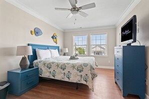 A bedroom with a bed, nightstands, a dresser, a ceiling fan, and a TV. - Epic 7BR Getaway - pool, game room, put-put, beach (North Myrtle Beach)