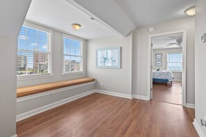 A room with a wooden bench, a ceiling fan, and a door leading to another room with a bed. - Epic 7BR Getaway - Pool, Game Room, Put-put, Beach (North Myrtle Beach)