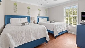 A hotel room with two beds, a ceiling fan, a window with a view, and a television on a stand. - Epic 7BR Getaway - Pool, Game Room, Put-put, Beach (North Myrtle Beach)