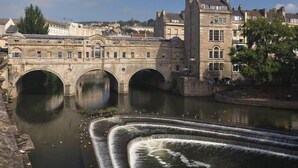 A stone bridge over a river with a water feature in the foreground. - Ringswell Gardens Room 3 Queen (Bath)