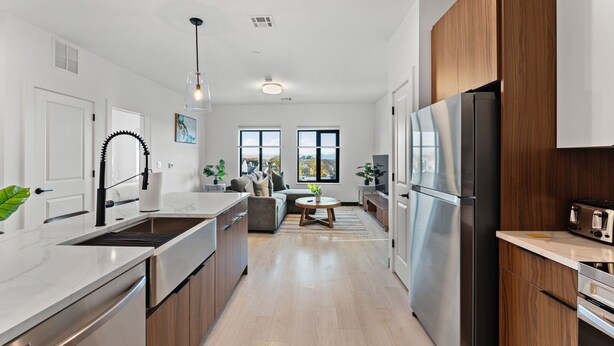 A modern kitchen with a central island, stainless steel appliances, and a view of the city. - Luxury 2bd/2ba near Boston sly2 (Everett)