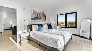 A modern hotel room with a large bed, a view of a cityscape, and a large window. - Luxury 2bd/2ba near Boston sly2 (Everett)