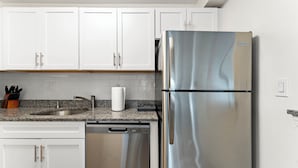 A kitchen with white cabinets, a stainless steel refrigerator, a granite countertop, and a dishwasher. - Nice 2bd/1.5ba Next to BU 7qn5 (Boston)