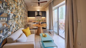 A modern living room with a sofa, a coffee table, and a dining area with a round table. - Rastoni Acropolis (Athens)