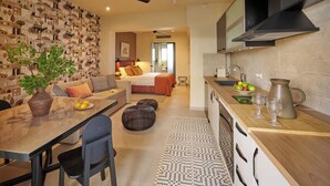 A modern hotel room with a dining area, kitchenette, and a bedroom. - Rastoni Acropolis (Athens)