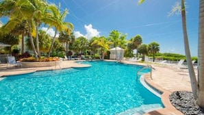 A swimming pool with clear blue water, surrounded by palm trees and lounge chairs. - PRIME LOCATION Islamorada Anglers Reef Oceanview Private Beaches, Pool & Marina (Islamorada)