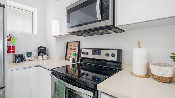Una cucina moderna con forno a microonde, fornelli e macchina da caffè.