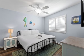 A bedroom with a bed, a nightstand, a lamp, a ceiling fan, a window with blinds, and a painting on the wall. - Mainsail 352 - Gulf Front Condo, Community Pool, Hot Tub, Free Beach Service! (Miramar Beach)