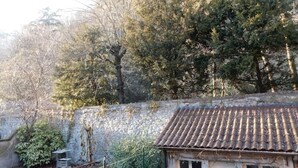 A rustic building with a tiled roof, surrounded by dense trees and a stone wall. - T3 au vert sup downtown Grenoble (Grenoble)