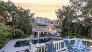 A two-story house with a pool, deck chairs, and a staircase leading to the upper level. - LUXURIOUS VILLA WATERFRONT NEAR SIESTA KEY BEACH (Sarasota)