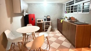 A compact kitchen with a dining area, a refrigerator, a microwave, and a sink. - Casa Paty! (Oaxaca de Juárez)