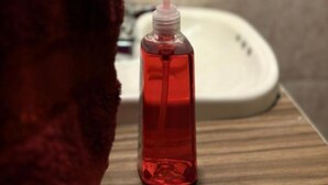A bathroom with a red bottle of liquid soap on a wooden surface. - Casa Paty! (Oaxaca de Juárez)