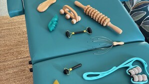 A teal massage table with various massage tools and accessories.