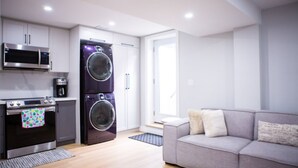 A modern kitchen with a microwave, oven, and washing machine. - Cozy and Private Basement apartment / Ideal for Relaxation or Work (Brampton)
