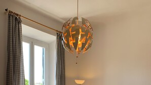 A living room with a sofa, a table, a floor lamp, and a hanging light fixture. - Flat nearby Vaticano - Caracciolo 4 (Rome)