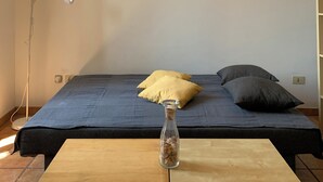 A room with a bed, a floor lamp, a table with a glass vase, and a ceiling light fixture. - Flat nearby Vaticano - Caracciolo 4 (Rome)
