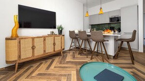 Une cuisine moderne avec un coin repas, un téléviseur fixé au mur et une table de billard.