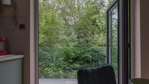 Une pièce dotée d’une grande fenêtre donnant sur une zone boisée.