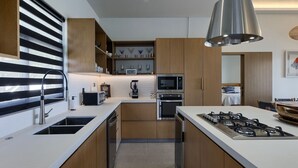 Uma cozinha moderna com ilha central, eletrodomésticos de aço inoxidável e armários de madeira.