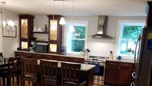 Une cuisine moderne avec un îlot central, des chaises en bois et une table à manger.