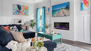 Un salon moderne avec un canapé bleu, une table basse turquoise et une cheminée.