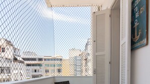 A balcony with two wicker chairs, a door, and a welcome sign. - Refuge in Copacabana for two | NSC1011 (Rio de Janeiro)