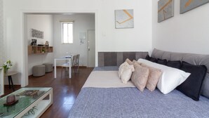 A modern bedroom with a large bed, a glass coffee table, a desk, and a chair. - Refuge in Copacabana for two | NSC1011 (Rio de Janeiro)