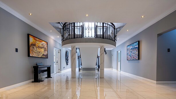 A spacious, well-lit hallway with a marble floor, a piano, and artwork on the walls. - Adinkra Boutique Hotel (Randburg)