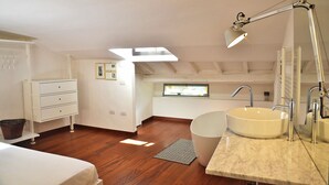 Ein modernes Badezimmer mit einem großen Waschbecken, einem Spiegel und einer Deckenleuchte.
