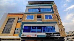 A multi-story hotel with a modern design, featuring large windows and a prominent sign for Hotel Shiv Chhaya. - Hotel Shiv Chhaya (Indore)
