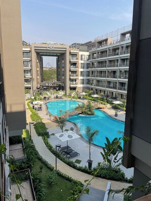 A modern apartment building with a swimming pool and outdoor seating areas. - The City Landing Apartments At Diamond (Accra)