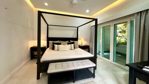 A four-poster bed with a bench, bedside tables, and a view of greenery through a sliding glass door. - Gorgeous Villa Marina Vallarta, pool, Free Shuttle (Puerto Vallarta)