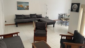 A living room with a sofa, chairs, a dining table, and a painting on the wall. - House with pool (Monastir)