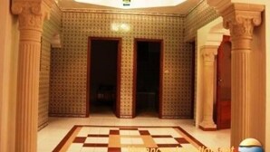 A hallway with patterned walls, a checkered floor, and classical columns. - House with pool (Monastir)