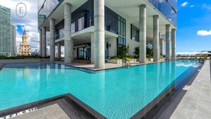 A modern building with a pool, large columns, and a view of a historic tower. - Relax in Luxury! 3 Bedroom Suite in Downtown Miami (Miami)