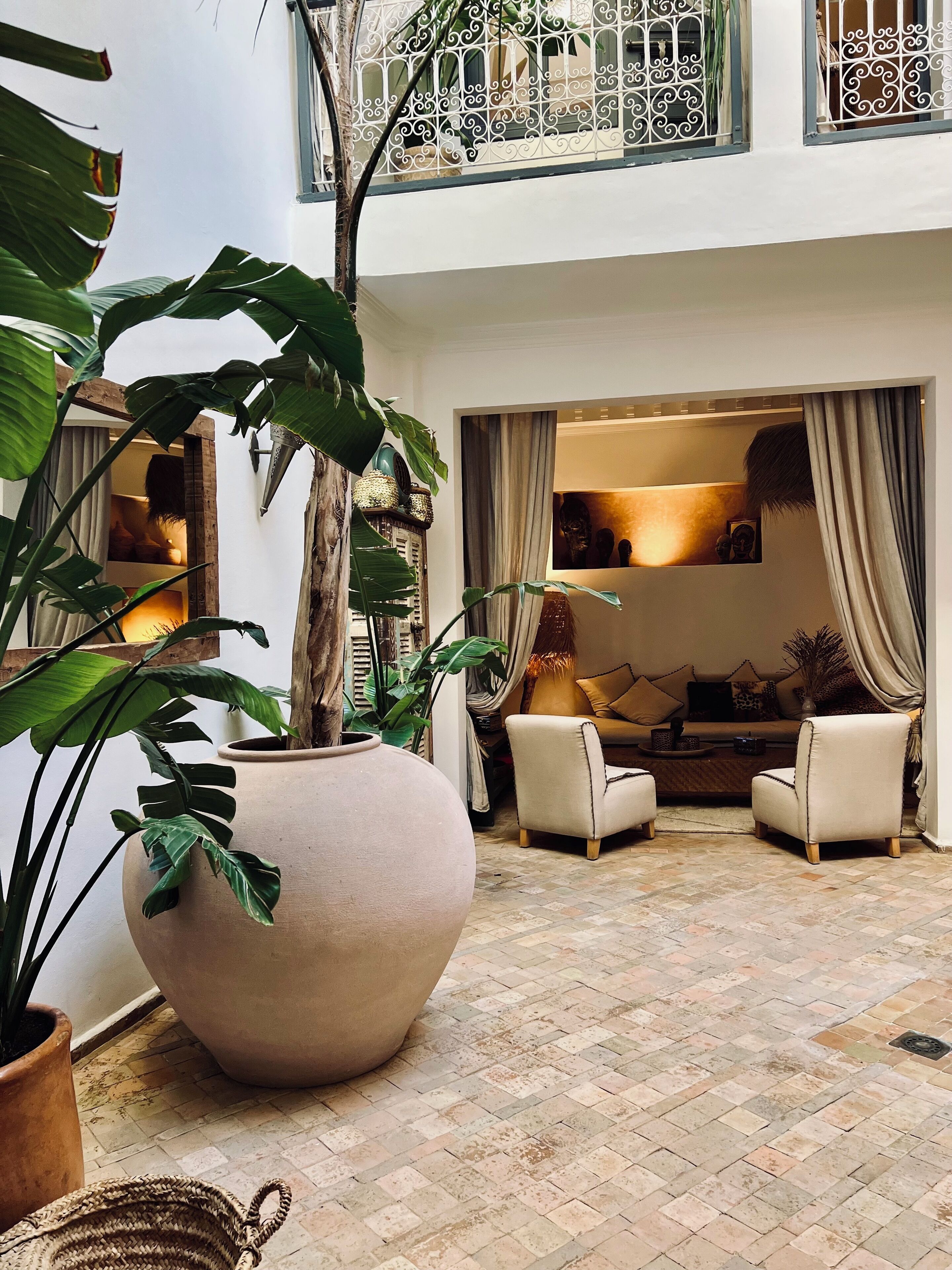 A spacious courtyard with a large planter, two armchairs, and a sofa.