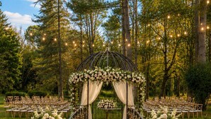 A wedding aisle with a floral archway, chairs, and lanterns. - Paradise in Provence: Chateau du Jonquier (Mazan)
